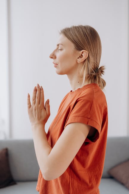 A serene woman with closed eyes practicing yoga in a beautifully lit room